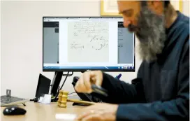  ?? (Ammar Awad/Reuters) ?? MERON EREN sits in his Jerusalem office yesterday near a computer showing a letter written by Richard Wagner.