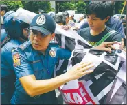  ?? THE ASSOCIATED PRESS ?? A Philippine policeman tries to block activists protesting martial law near the Supreme Court in Manila on Tuesday.