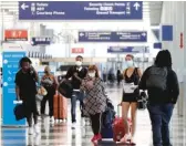  ?? NAM Y. HUH/AP FILE ?? Travelers walk through Terminal 3 at O’Hare Airport in June. Starting Monday, most people arriving in Chicago from a state seeing a surge in coronaviru­s cases must quarantine for two weeks.