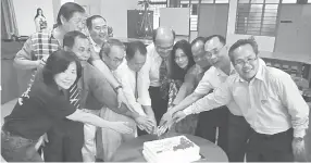  ??  ?? Yunus (centre), and Fr Paul (on his right), lead the cutting of the cake.