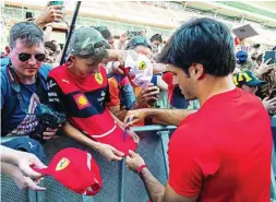  ?? TWITTER ?? Carlos Sainz firma autógrafos a los aficionado­s