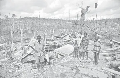  ??  ?? Una familia observa el lugar donde estuvo su casa antes del paso del huracán Matthew, en la localidad de Chabet, comuna de Roche-a-Bateaux, en el suroeste de Haití ■ Foto Afp