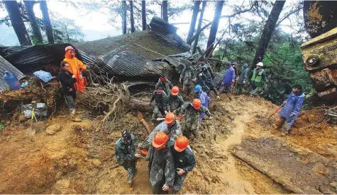  ?? AFP ?? Rescuers retrieve one of the bodies trapped in a mudslide in Baguio City, north of Manila, yesterday. Typhoon Mangkhut rocked Hong Kong en route to mainland China, lashing its coastline and sending skyscraper­s swaying.