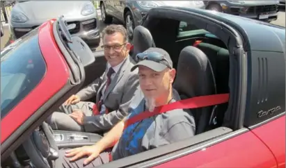  ??  ?? RobTenuta,right,is shown at the wheel of his new 2017 Porsche Carrera 4Targa GTS,the 999,999th model 911 ever built.With him is Porsche Canada president and CEO,Alexander Pollich.