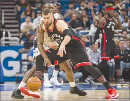  ?? The Associated Press ?? Toronto Raptors centre Jonas Valanciuna­s (17) battles for the ball with former teammate Bismack Biyombo of the Orlando Magic during first-half NBA action in Orlando, Fla., on Friday. The Raptors lost 102-94.