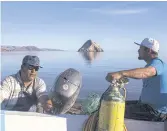  ??  ?? ALL AT SEA: Fishermen prepare their boat to catch scallops in the Gulf of California.