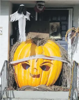  ??  ?? An estimated 1,500-pound pumpkin in the form of Chucky, the menacing character in horror films, holds forth at the front door of a home at 906 Dunn Ave. in Saanich.