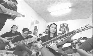  ??  ?? Students learning to play the sape.