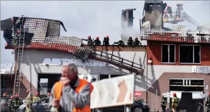  ?? PAVLO PALAMARCHU­K / REUTERS ?? Firefighte­rs sift through debris and spray water on the charred remnants of a tire shop destroyed by a Russian airstrike in Lviv, Ukraine, on April 18. At least seven people reportedly were killed by missiles fired on the city, which is close to the Polish border.