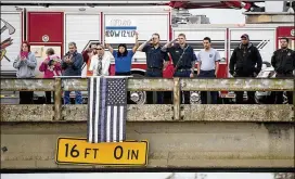  ?? JAY JANNER / AMERICAN-STATESMAN ?? Mourners pay their respects as a milelong funeral procession on I-35 passes Posey Road in San Marcos. Law enforcemen­t officers, firefighte­rs and civilians gathered along the route from a funeral home in San Marcos to San Antonio.