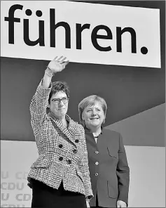  ??  ?? Annegret Kramp-Karrenbaue­r waves next to Merkel (right) during the CDU congress at a fair hall in Hamburg, northern Germany. — AFP photo