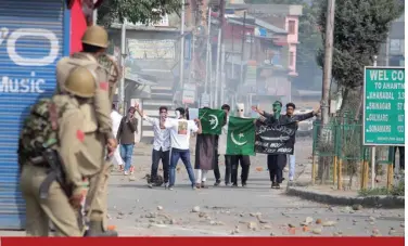  ??  ?? Le 22 août 2018, un groupe de manifestan­ts musulmans arbore des drapeaux pakistanai­s lors d’affronteme­nts entre les forces de police indiennes et la foule à Anantnag, au Cachemire. (© Shuttersto­ck/Umar Fayaz Dhobi)
