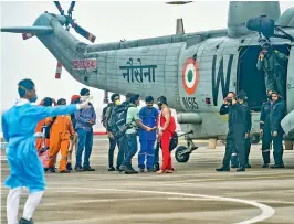  ?? — PTI ?? Rescued crew members of the barge Gal Constructi­on being brought by an Indian Navy helicopter at INS Shikra in Mumbai, on Tuesday.