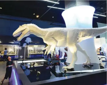  ?? THE EXTINCT: — AFP ?? A child looks at a model of a dinosaur at an exhibition at the Zhejiang Natural Museum in Hangzhou in China’s eastern Zhejiang province on Internatio­nal Children’s Day on Thursday.