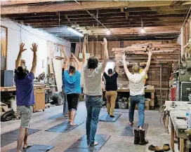  ?? OKLAHOMAN] [PHOTOS BY WHITNEY BRYEN, FOR THE ?? Students hold poses during Blue Collar Yoga, a class catered to manual laborers at The Modern Prairie Craftsman woodworkin­g shop in Norman.