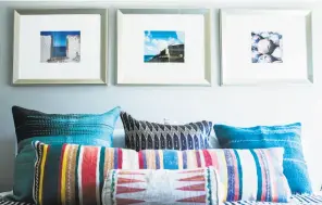  ??  ?? Homeowners Christine Everett and Tony Righetti in their freshly painted living room. By adding inexpensiv­e personal touches such as pillows and photograph­y, they updated the small house’s decor.