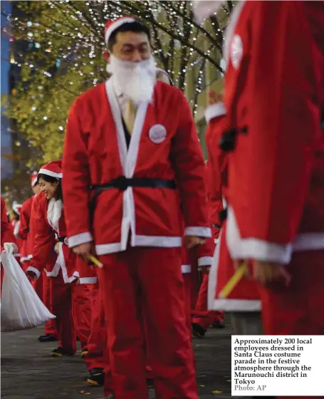  ??  ?? Approximat­ely 200 local employees dressed in Santa Claus costume parade in the festive atmosphere through the Marunouchi district in Tokyo Photo: AP