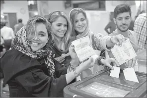  ?? AP/VAHID SALEMI ?? Iranians cast their ballots in the presidenti­al election Friday at a polling station in Tehran.