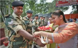  ?? — PTI ?? A woman ties a “rakhi” on the wrist of a Border Security Force soldier during the “Raksha Bandhan” festival celebratio­ns in Suchatgarh, near Jammu, on Friday.