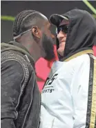  ?? JOHN GURZINSKI/AFP VIA GETTY IMAGES ?? Heavyweigh­t champion Deontay Wilder, left, and Tyson Fury have a discussion about their Saturday night fight in Las Vegas.