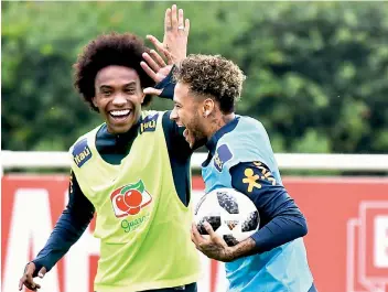  ?? — AFP ?? Brazil players Willian (left) and Neymar enjoy a light moment during a training session at Tottenham Hotspur’s Enfield Training Centre in London on Wednesday.
