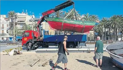  ??  ?? Un camió grua retira una de les tres barques que l’Ajuntament vol convertir en un símbol