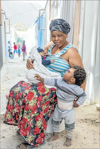  ?? Pictures: Anton Crone ?? MAKING THE BEST OF IT Left, Nonstapho Maqabuka outside the shack she shares with her daughter and her two grandchild­ren — Alunamda, on her lap, and Inako, standing. Right, Cisco Ramosie and Emihle Morris slide down a pile of rubble at a constructi­on site for formal housing, chased by their friends Mark Boois and Kyle Anthony.