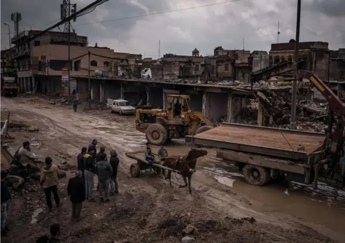  ?? © ?? Arbeiders verzamelen metaal van tussen de ruïnes in Mosul (Irak) in maart 2019. Sergey
Ponomarev/nyt