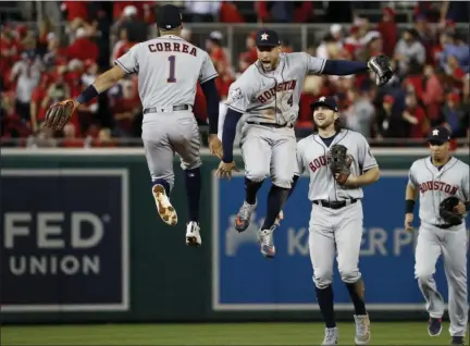  ?? JEFF ROBERSON - THE ASSOCIATED PRESS ?? Houston Astros shortstop Carlos Correa, left, and right fielder George Springer celebrate after their teams win against the Washington Nationals in Game 5 of the World Series Sunday, Oct. 27, 2019, in Washington. The Astros won 7-1 to take a 3-2 lead in the series.