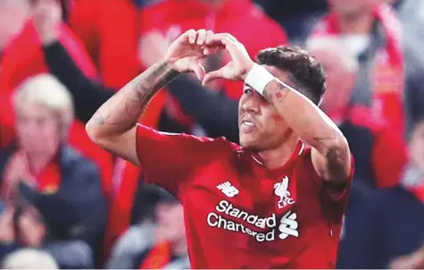  ?? Reuters ?? Liverpool’s Roberto Firmino celebrates after scoring the team’s third goal to provide a thrilling climax to a pulsating night at Anfield to open Champions League Group C. Firmino, doubtful due to an eye injury, grabbed his chance with both hands to help Liverpool win.