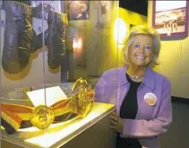  ??  ?? Mary Louise Conn poses with her husband’s 1939 light heavyweigh­t championsh­ip belt.