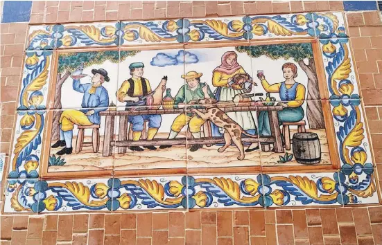  ?? Fotos: Marco Schicker/dpa ?? Essen und Trinken als des Lebens Sinn und Zweck. Azulejo-Illustrati­on an der Mariscería del Barrio in Alicante.