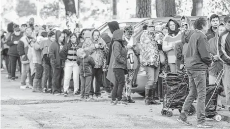  ?? Steve Gonzales / Staff photograph­er ?? People waited in the cold Tuesday to receive goods at the East Spring Branch Food Pantry. The agency provided at least 1,200 families with Thanksgivi­ng delicacies. “You leave feeling so good about life and people,” says director Mary White.