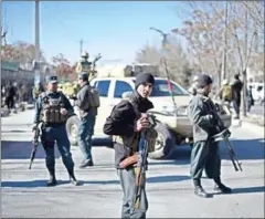  ?? SHAH MARAI/AFP ?? Afghan policemen stand guard after explosions at a Shiite cultural centre in Kabul on December 28.