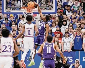  ?? Nick Krug/Associated Press ?? TCU guard Shahada Wells drives in for a dunk past Kansas guard Joseph Yesufu during the first half Saturday at Allen Fieldhouse.