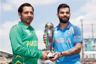  ??  ?? India's captain Virat Kohl, right, and Pakistan's captain Sarfraz Ahmed pose for a picture with the trophy at the Oval cricket ground in London Saturday, ahead of the two teams' clash in the ICC Champions Trophy final cricket match at the Oval on...