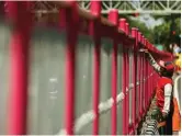  ?? DIPTA WAHYU/JAWA POS ?? JADI CIAMIK: Sejumlah petugas mengecat warna pink pada besi pembatas Jalan Urip Sumoharjo kemarin.