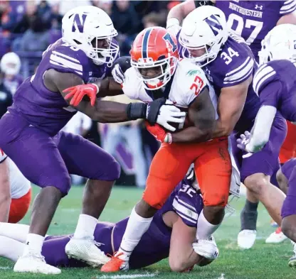 ?? NAM Y. HUH/AP ?? Illinois’ Reggie Love III is swarmed by Northweste­rn tacklers. The Illini have improved from a 5-7 record last season to 8-4.