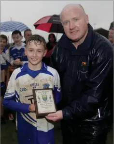  ??  ?? Wicklow People man of the match Conaill O’Brein of Aughrim receives his award from Pat Dunne.