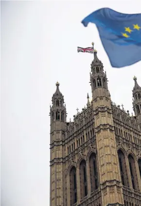  ??  ?? > EU flags are waved by protesters outside Parliament yesterday