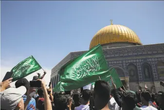  ?? Mahmoud Illean / Associated Press ?? Worshipers wave Hamas flags during a protest at the AlAqsa Mosque in the Old City of Jerusalem against the likely evictions of Palestinia­n families from their homes.