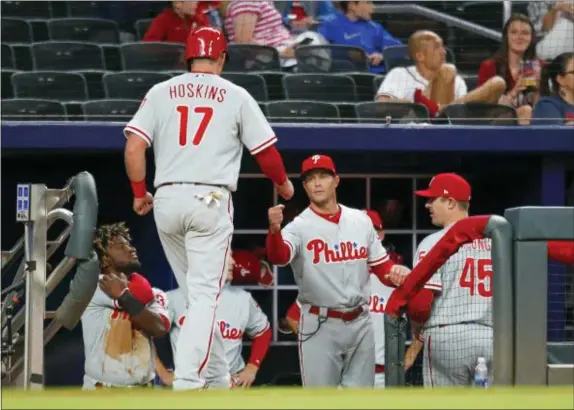  ?? THE ASSOCIATED PRESS ?? Phillies manager Gabe Kapler fist-bumps Rhys Hoskins (17) after Hoskins scored during a recent game against the Atlanta Braves.