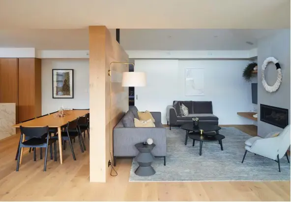  ??  ?? ABOVE An oak-panelled partition divides the kitchen/ dining and living areas; in the former is a solid-oak dining table designed by Trinity and made by Classique, with Tangerine chairs by Simon James. The framed work on the wall is a keepsake from Nicole’s travels in Africa, while the art in the living area is by Jane Mason. The Hug chair on the far right in this space is by Wendelbo from Bauhaus.