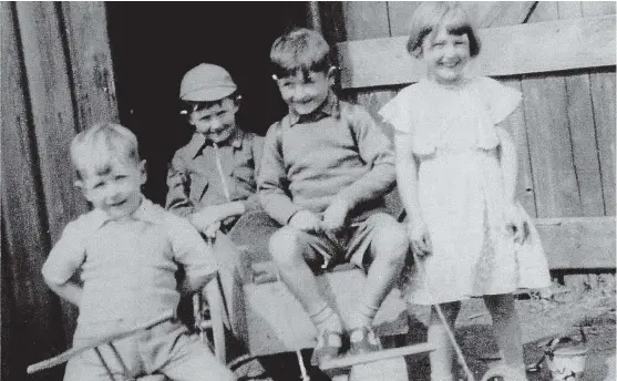  ??  ?? Albert Merralls of Errol has sent this photograph of himself (in the centre) with his brother Stuart (left), sister May and cousin Brian Fitzgerald at the back. “We are sitting on a ‘bogie’ built by my father,” he says. “The picture was taken at...