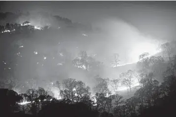  ?? JOSE CARLOS FAJARDO/BAY AREA NEWS GROUP ?? California fires: A fire sparked by a lightning strike burns Monday on a hillside in Brentwood, California, east of the Bay Area. A thundersto­rm that moved onshore from the Pacific Ocean on Sunday in northern California resulted in thousands of lightning strikes in the region. Some ignited blazes in a state that’s also been dealing with a heat wave.