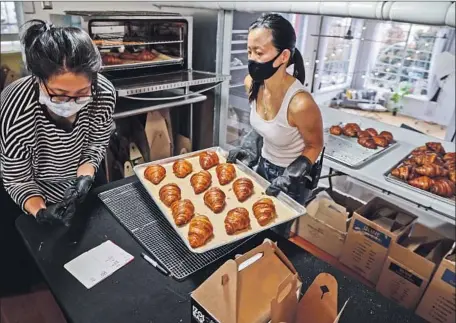  ?? Photog r aphs by Eduardo Contreras San Diego Union- Tribune ?? BAKER Jennifer Chen, right, and Jasmine Liu prepare croissants at Izola Bakery in San Diego, started by Chen’s life partner, Jeffrey Lamont Brown. The bakery was the brainchild of Brown after his commercial photograph­y business slowed due to the pandemic.