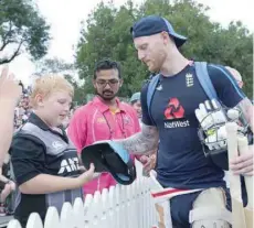  ?? — AFP ?? England’s Ben Stokes (right), who is not playing, signs autographs during the Twenty20 Tri Series internatio­nal cricket match between New Zealand and England at Seddon Park in Hamilton on February 18, 2018.