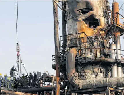  ?? HAMADI MOHAMMED REUTERS • ?? Workers are seen at the damaged site of Saudi Aramco oil facility in Abqaiq, Saudi Arabia.