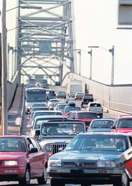  ?? HERALD FILE PHOTO ?? THEY KNOW WHERE THEY’RE GOING: Cars head into the town of Bourne, on the Cape, via the Bourne Bridge.