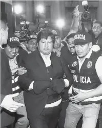  ?? — Gambar AFP ?? PADAH DITERIMA: Gambar dikeluarka­n oleh Kehakiman Peru menunjukka­n Oviedo (tengah) selepas penangkapa­nnya terhadap tuduhan rasuah di Lima pada 6 Disember 2018.